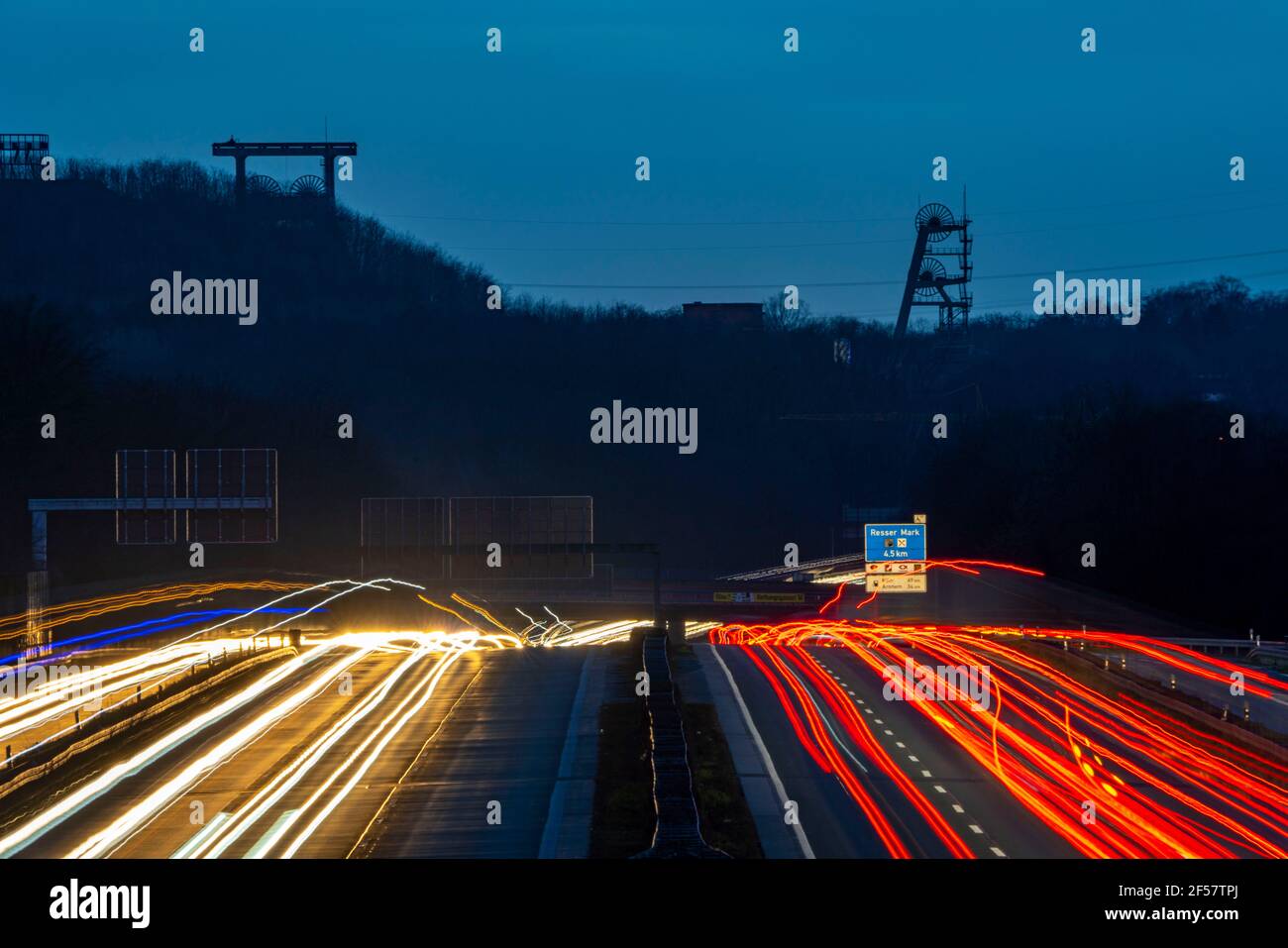 Traffico serale sull'autostrada A2 al bivio di Recklinghausen in direzione ovest, sullo sfondo le tortuose torri dell'ex collisione di Ewald, NRW Foto Stock
