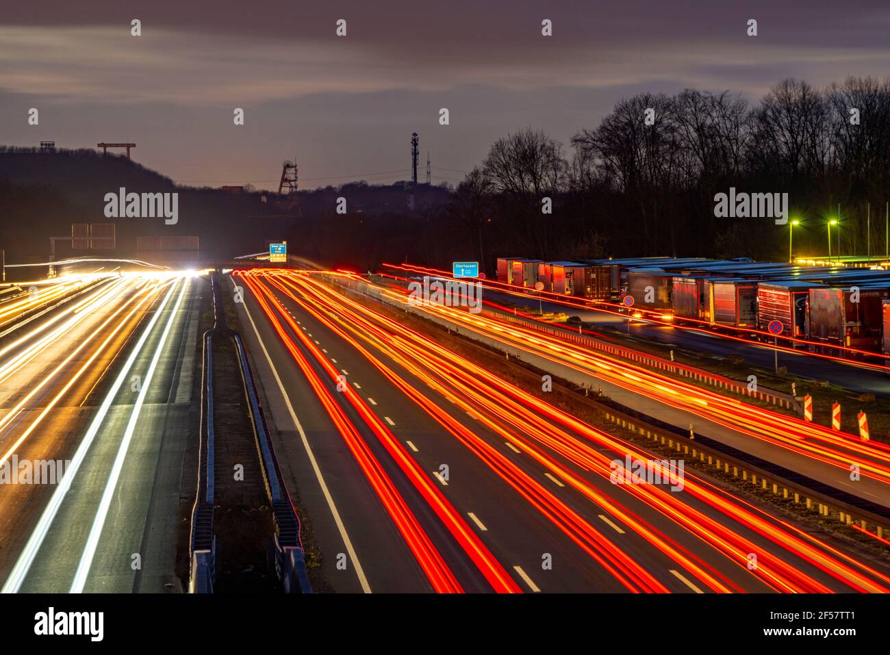 Traffico serale sull'autostrada A2 allo svincolo di Recklinghausen in direzione ovest, sullo sfondo le tortuose cornici dell'ex collera di Ewald, Hoh Foto Stock