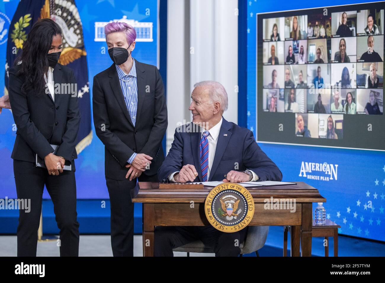 Washington, Stati Uniti. 24 Marzo 2021. Il Presidente DEGLI STATI UNITI Joe Biden, con Margaret Purce (L), Megan Rapinoe (C) e altri membri della squadra nazionale delle donne di calcio degli Stati Uniti, firma un annuncio durante un evento per celebrare la Giornata della parità di retribuzione nella Sala da pranzo dello Stato della Casa Bianca a Washington, DC il 24 marzo 2021. EQUAL Pay Day segna il tempo extra che una donna media negli Stati Uniti impiega per guadagnare la stessa retribuzione che i loro colleghi maschi hanno fatto l'anno civile precedente. Foto in piscina di Shawn Thew Credit: UPI/Alamy Live News Foto Stock