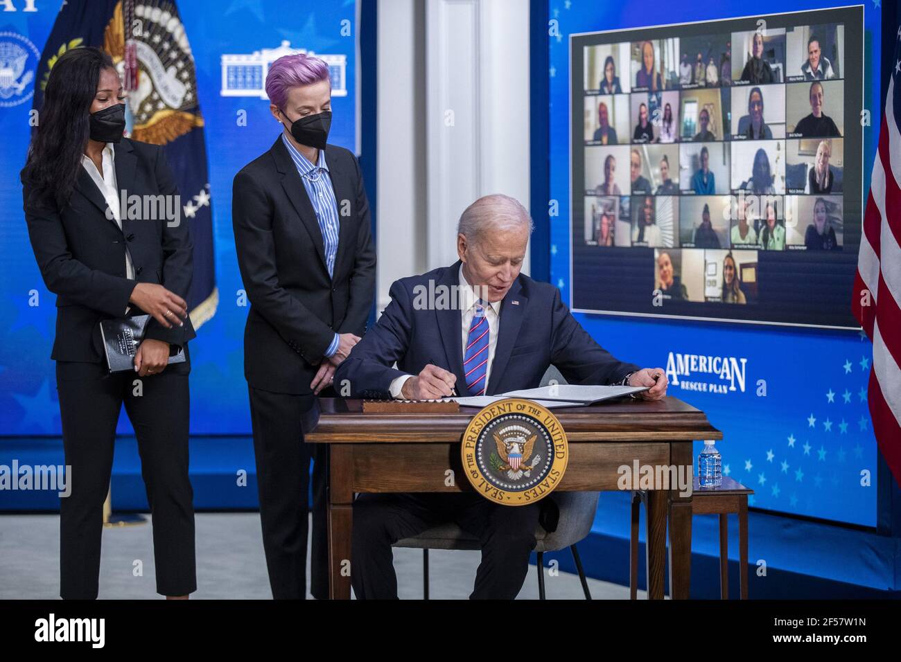 Washington, Stati Uniti. 24 Marzo 2021. Il Presidente DEGLI STATI UNITI Joe Biden, con Margaret Purce (L), Megan Rapinoe (C) e altri membri della squadra nazionale delle donne di calcio degli Stati Uniti, firma un annuncio durante un evento per celebrare la Giornata della parità di retribuzione nella Sala da pranzo dello Stato della Casa Bianca a Washington, DC il 24 marzo 2021. EQUAL Pay Day segna il tempo extra che una donna media negli Stati Uniti impiega per guadagnare la stessa retribuzione che i loro colleghi maschi hanno fatto l'anno civile precedente. Foto in piscina di Shawn Thew Credit: UPI/Alamy Live News Foto Stock