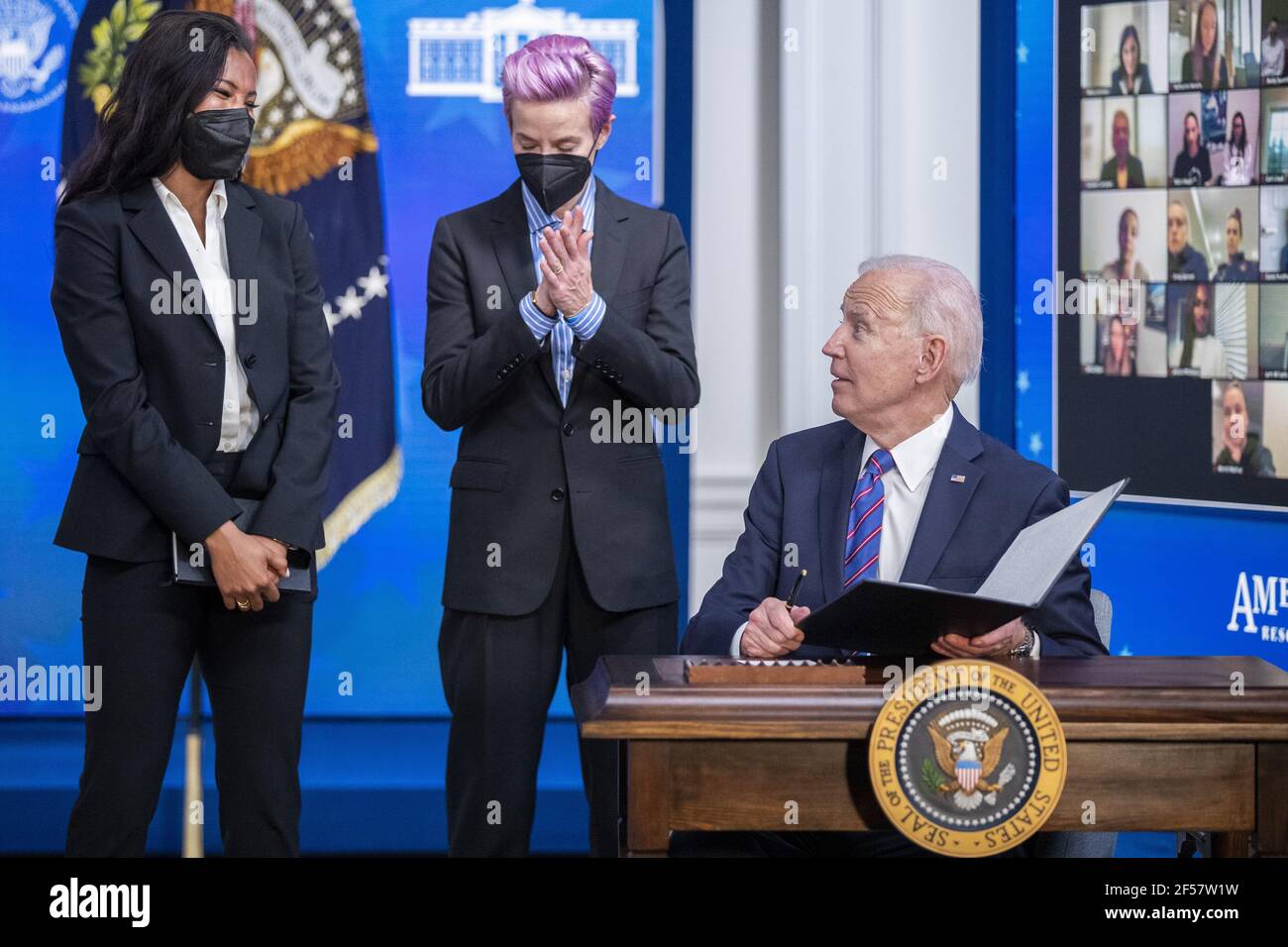 Washington, Stati Uniti. 24 Marzo 2021. Il Presidente DEGLI STATI UNITI Joe Biden, con Margaret Purce (L), Megan Rapinoe (C) e altri membri della squadra nazionale delle donne di calcio degli Stati Uniti, firma un annuncio durante un evento per celebrare la Giornata della parità di retribuzione nella Sala da pranzo dello Stato della Casa Bianca a Washington, DC il 24 marzo 2021. EQUAL Pay Day segna il tempo extra che una donna media negli Stati Uniti impiega per guadagnare la stessa retribuzione che i loro colleghi maschi hanno fatto l'anno civile precedente. Foto in piscina di Shawn Thew Credit: UPI/Alamy Live News Foto Stock
