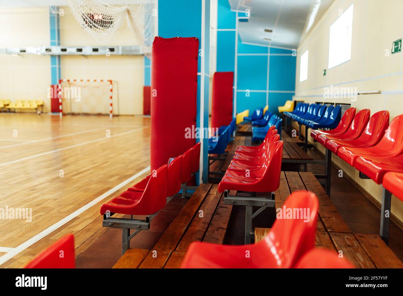 colorato significa tifosi in uno stadio al coperto. posti a sedere nella sala sportiva per le competizioni. panca vuota dei giocatori di riserva Foto Stock