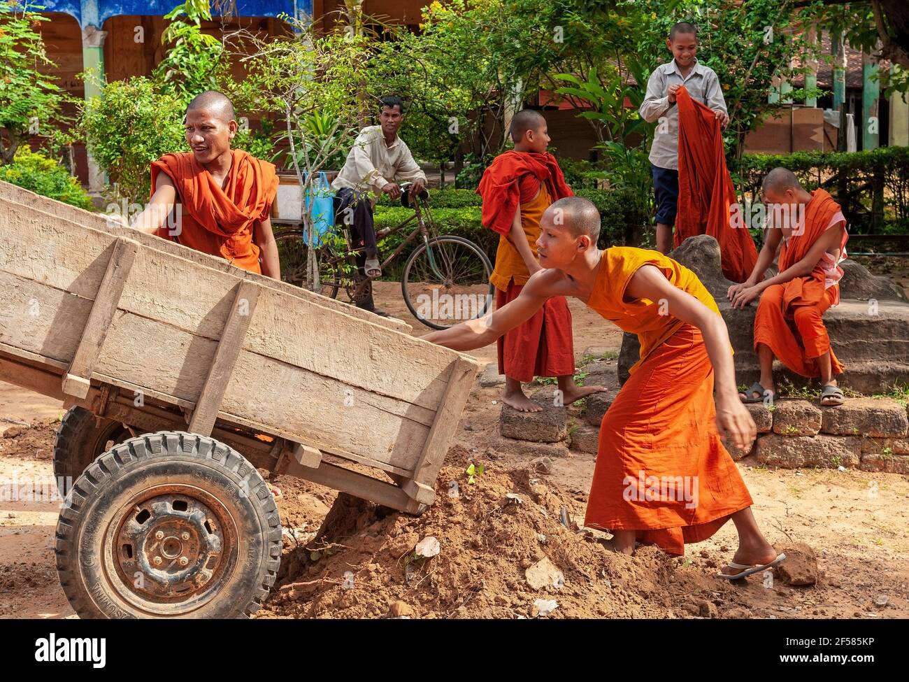 I monaci buddisti Theravada in tradizionale accappatoio arancione stanno facendo lavori di restauro in un tempio. Foto Stock