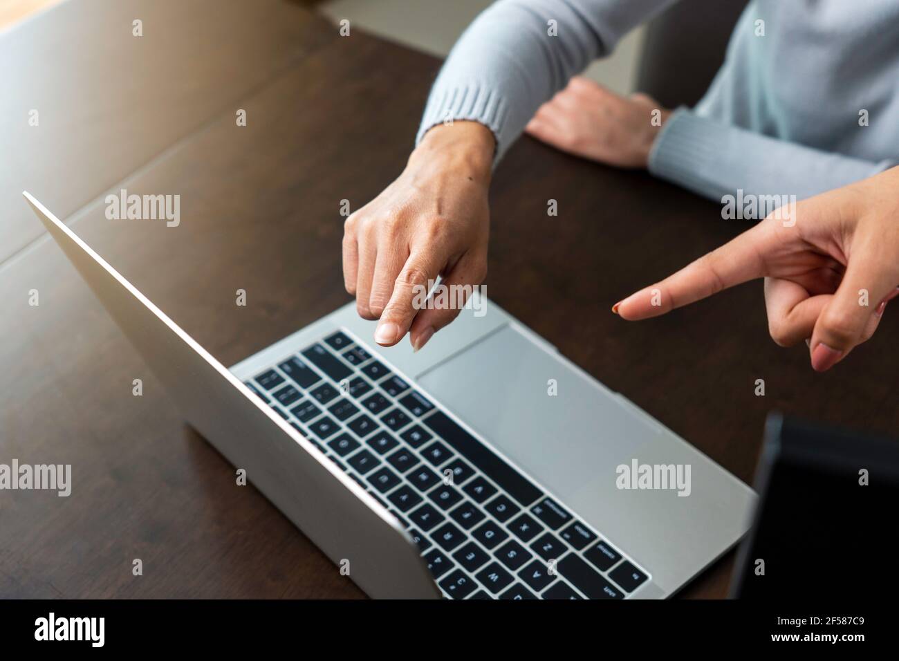 Le dita delle due donne di affari hanno puntato allo schermo del laptop per analizzare i dati di affari. Foto Stock