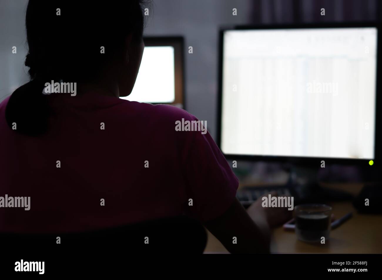 Donna che lavora il suo lavoro da casa utilizzando il computer connettersi al suo ufficio giorno per notte. Foto Stock