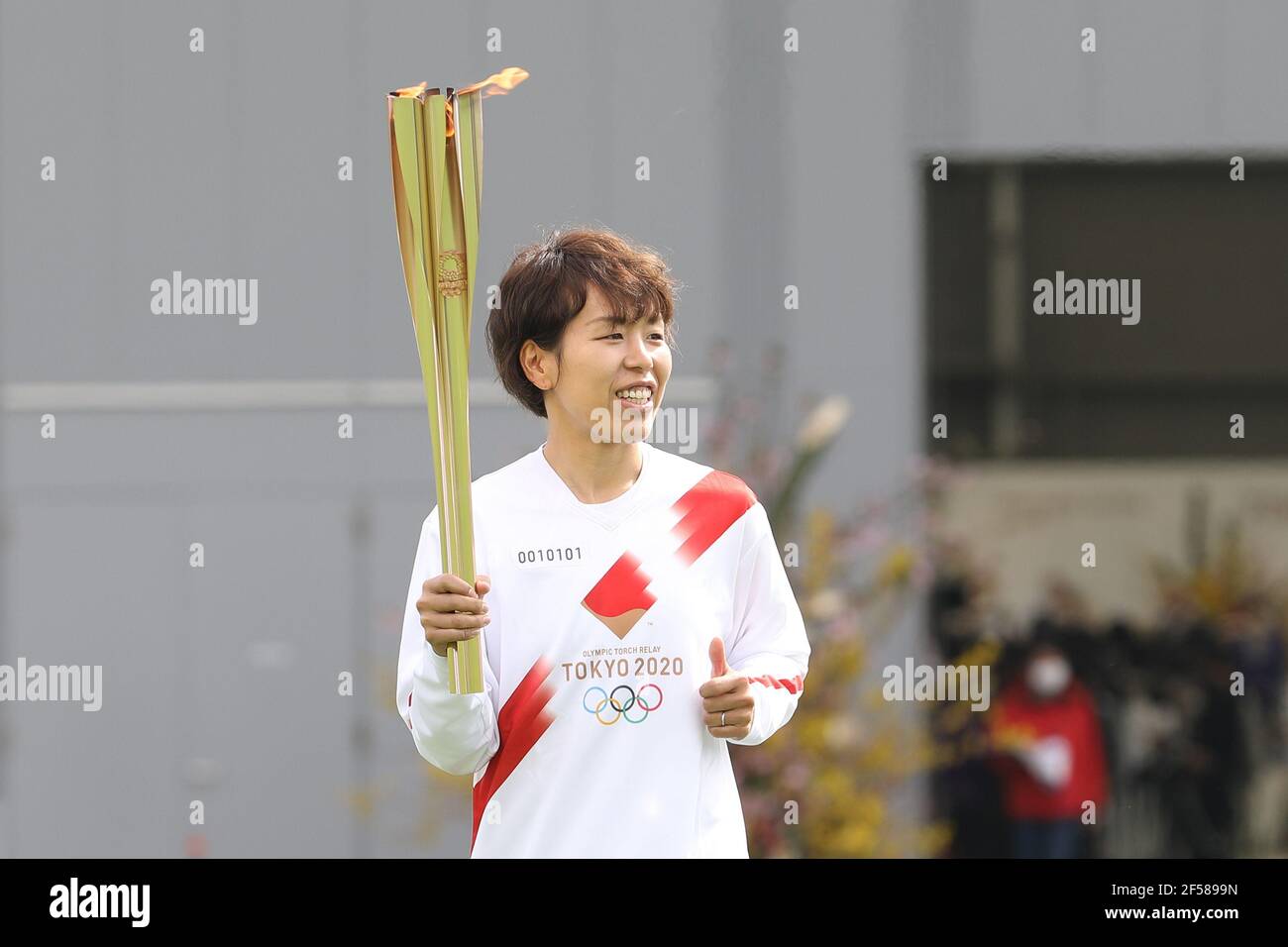 Fukushima, Fukushima del Giappone. 25 Marzo 2021. Iwashimizu Azusa, un membro della 'Nadeshiko Japan', la Nazionale femminile del Giappone, corre come portabandiera nella prima tappa della torcia per i Giochi Olimpici di Tokyo al J-Village National Training Center a Futaba, Fukushima del Giappone, il 25 marzo 2021. Credit: Du Xiaoyi/Xinhua/Alamy Live News Foto Stock