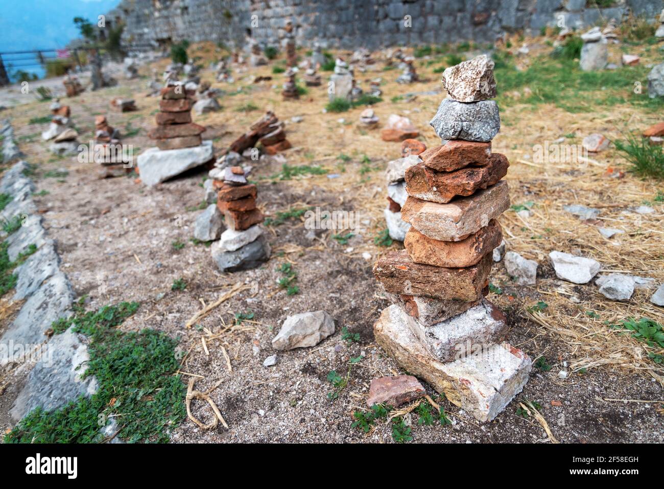 Piccole pile os pietre accuratamente accatastate e disposte dalla gente, posto accanto ad un percorso dalle pareti di Fort Kotor. Foto Stock