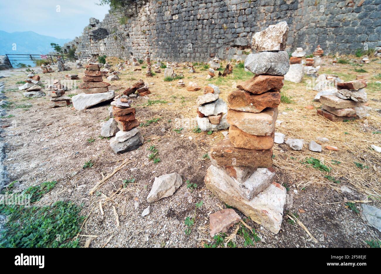 Piccole pile os pietre accuratamente accatastate e disposte dalla gente, posto accanto ad un percorso dalle pareti di Fort Kotor. Foto Stock