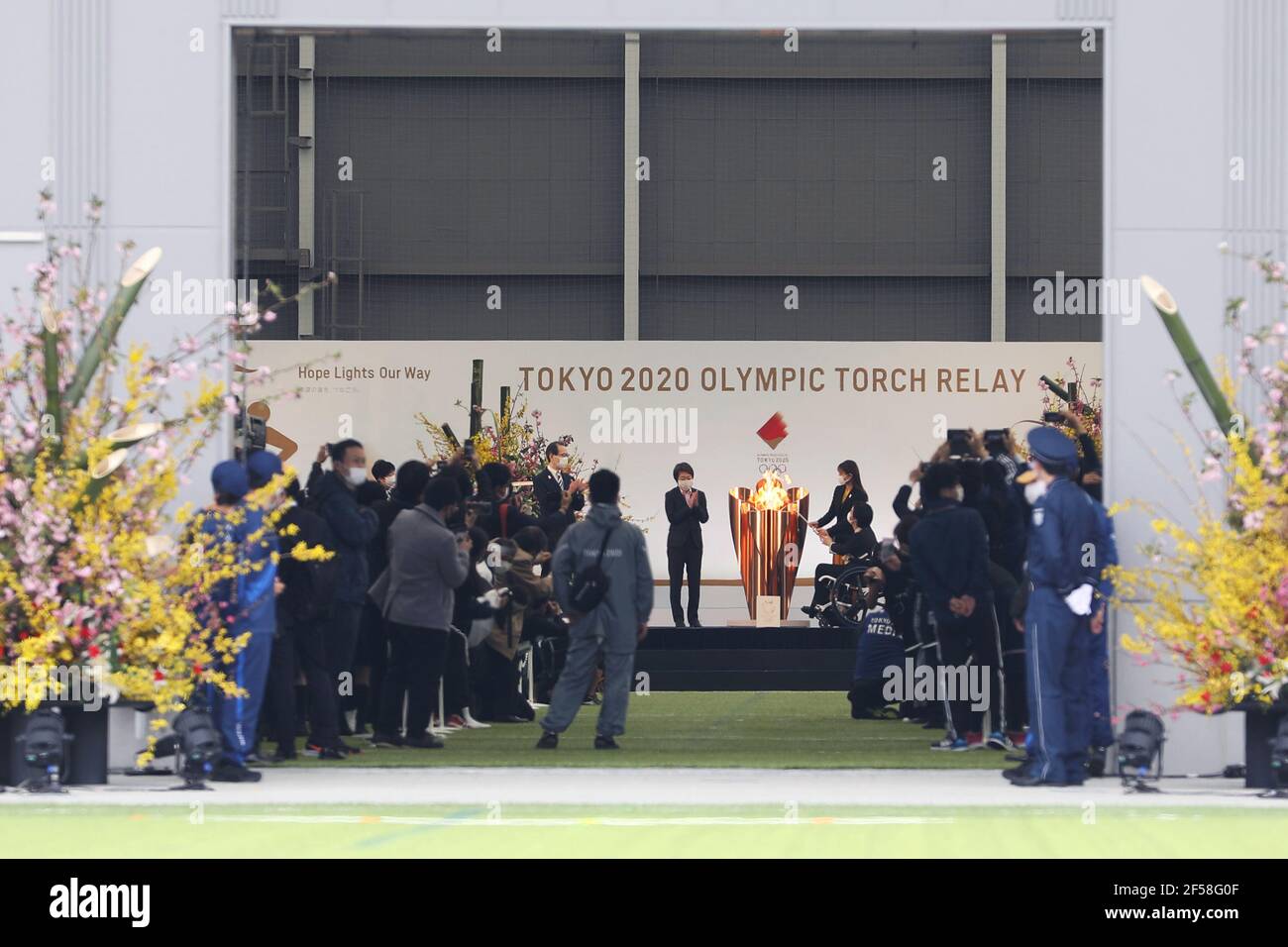 Fukushima, Fukushima del Giappone. 25 Marzo 2021. Ambasciatore ufficiale della torcia elettrica Tokyo 2020 Ishihara Satomi (sul palco, 2° R) e Paralympian Taguchi Aki (sul palco, 1° R) accendere il calderone di celebrazione durante la grande cerimonia di avvio della torcia elettrica per i Giochi Olimpici di Tokyo presso il J-Village National Training Center di Futaba, Fukushima del Giappone, il 25 marzo 2021. Credit: Du Xiaoyi/Xinhua/Alamy Live News Foto Stock