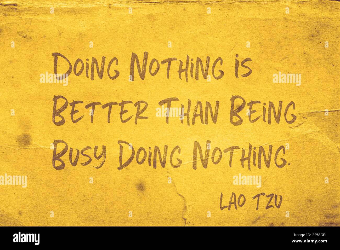 Non fare nulla è meglio di essere impegnati a non fare nulla - L'antico filosofo cinese Lao Tzu citazione stampata su grunge giallo carta Foto Stock