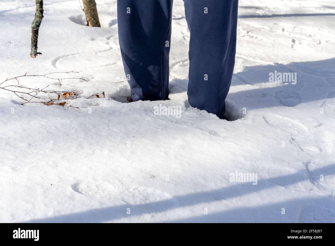 l'uomo è caduto in una deriva di neve. gambe ravvicinato. livello di neve alto. ginocchio profondo nella neve Foto Stock