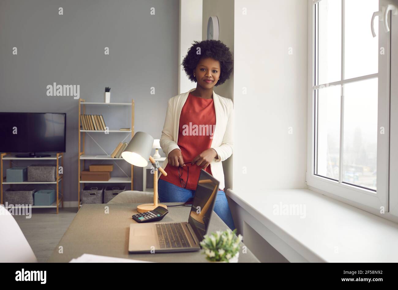 Giovane donna d'affari afro-americana sorridente di successo in ritratto d'ufficio Foto Stock