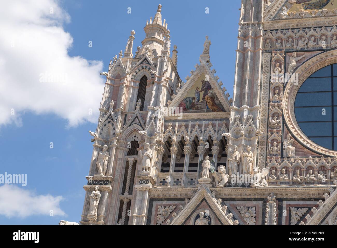 Mosaico e finestra circolare sulla facciata del Duomo, Siena, Italia Foto Stock