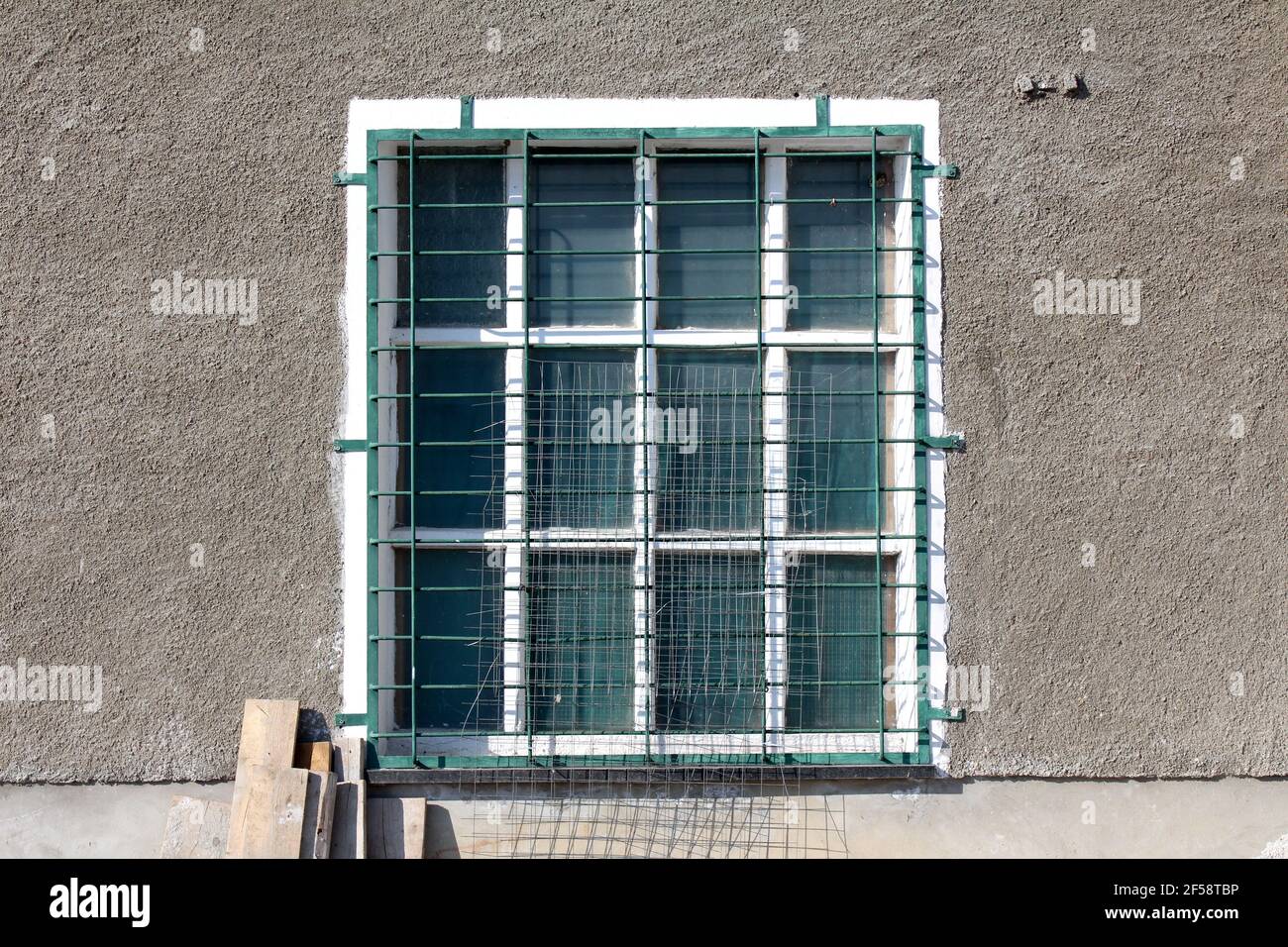 Antica finestra retrò vintage con cornice in legno bianco e metallo barra  di protezione montata su parete di edifici industriali con tavole di legno  e rete metallica Foto stock - Alamy