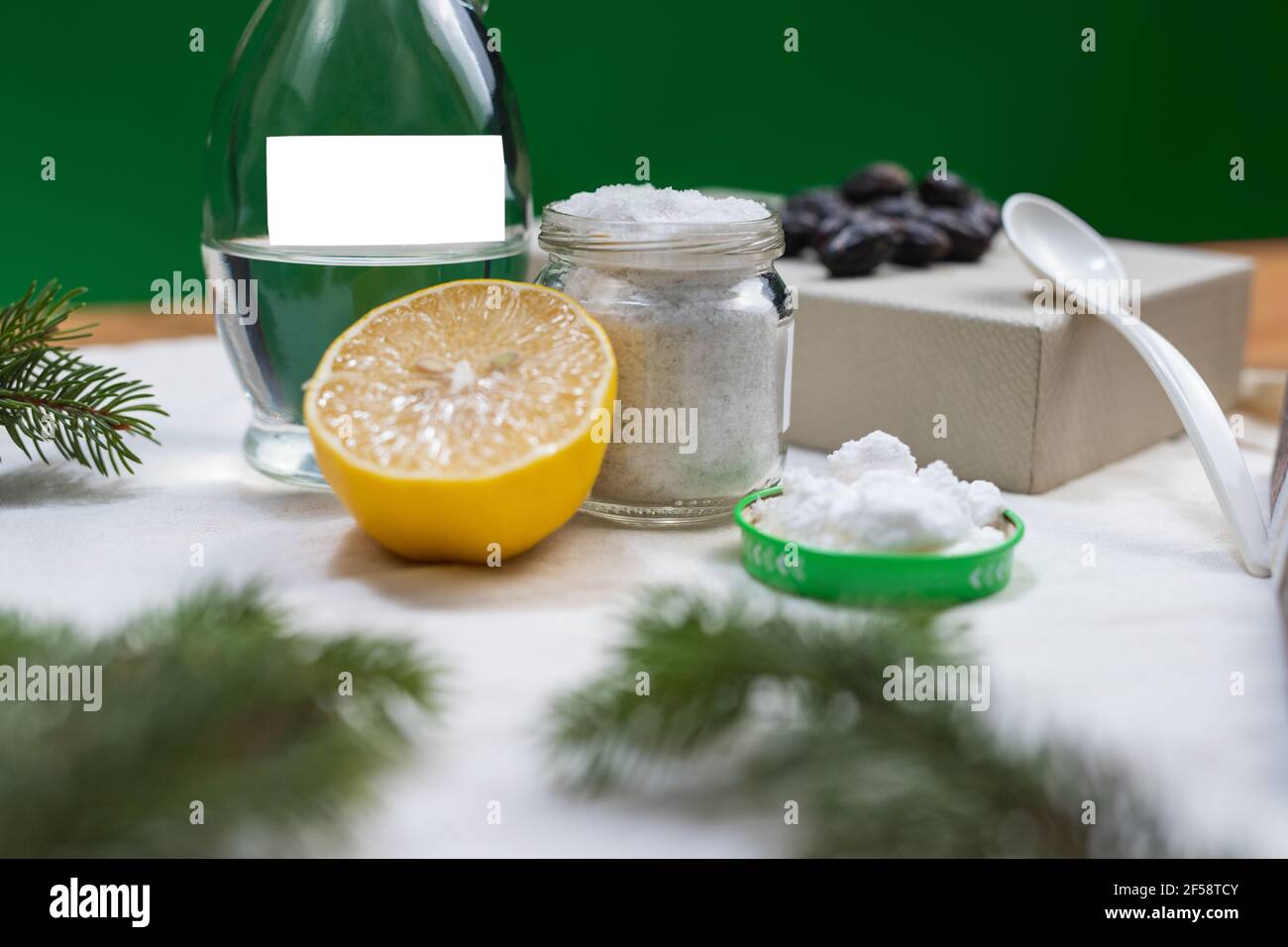 Detergenti naturali ecologici. Aceto con acqua, bicarbonato di sodio, sale,  limone pronto per la misurazione, fondo di panno bianco e cornice di abete  verde Foto stock - Alamy
