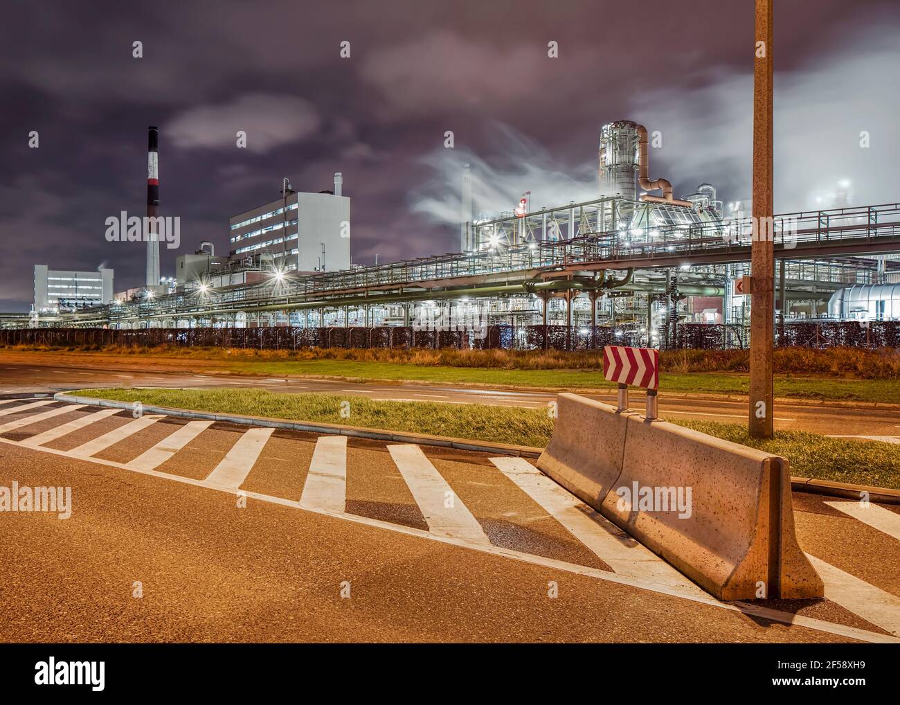 Scena notturna con l'industria petrolchimica e stradale sullo sfondo di notte. Porto di Anversa, Belgio. Foto Stock