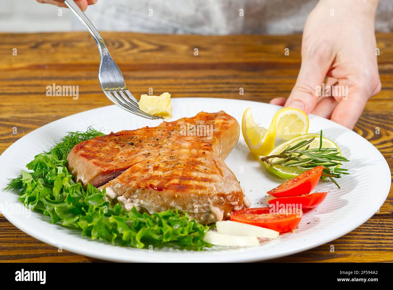 Bistecca di tonno cucinata alla griglia elettrica. Tunapiatti serviti su un piatto con erbe e verdure fresche. Alimentazione sana e nutriente per una sana salute Foto Stock