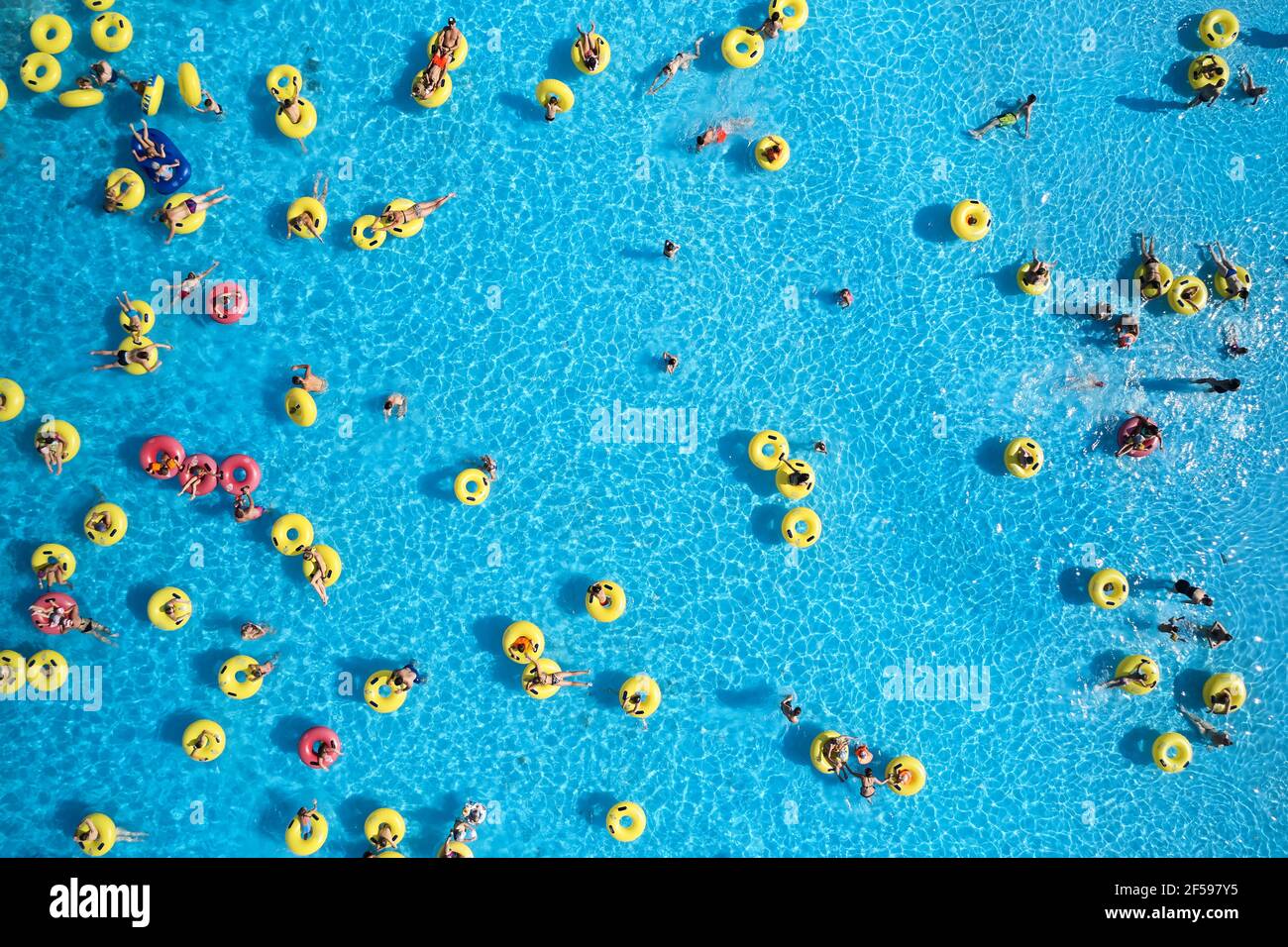 Sfondo del parco acquatico. Vista dall'alto - i giovani si rilassano in piscina presso la vasca a bolle d'aria. Foto Stock