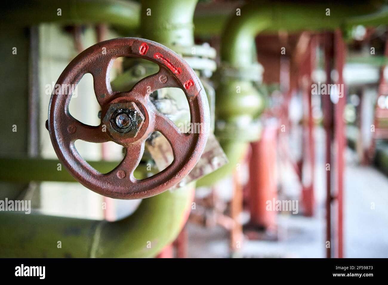 Distributore idraulico selettivo in stile retrò chimico industriale mettere in primo piano il volante marrone montato con il collegamento della flangia attivato verde Foto Stock