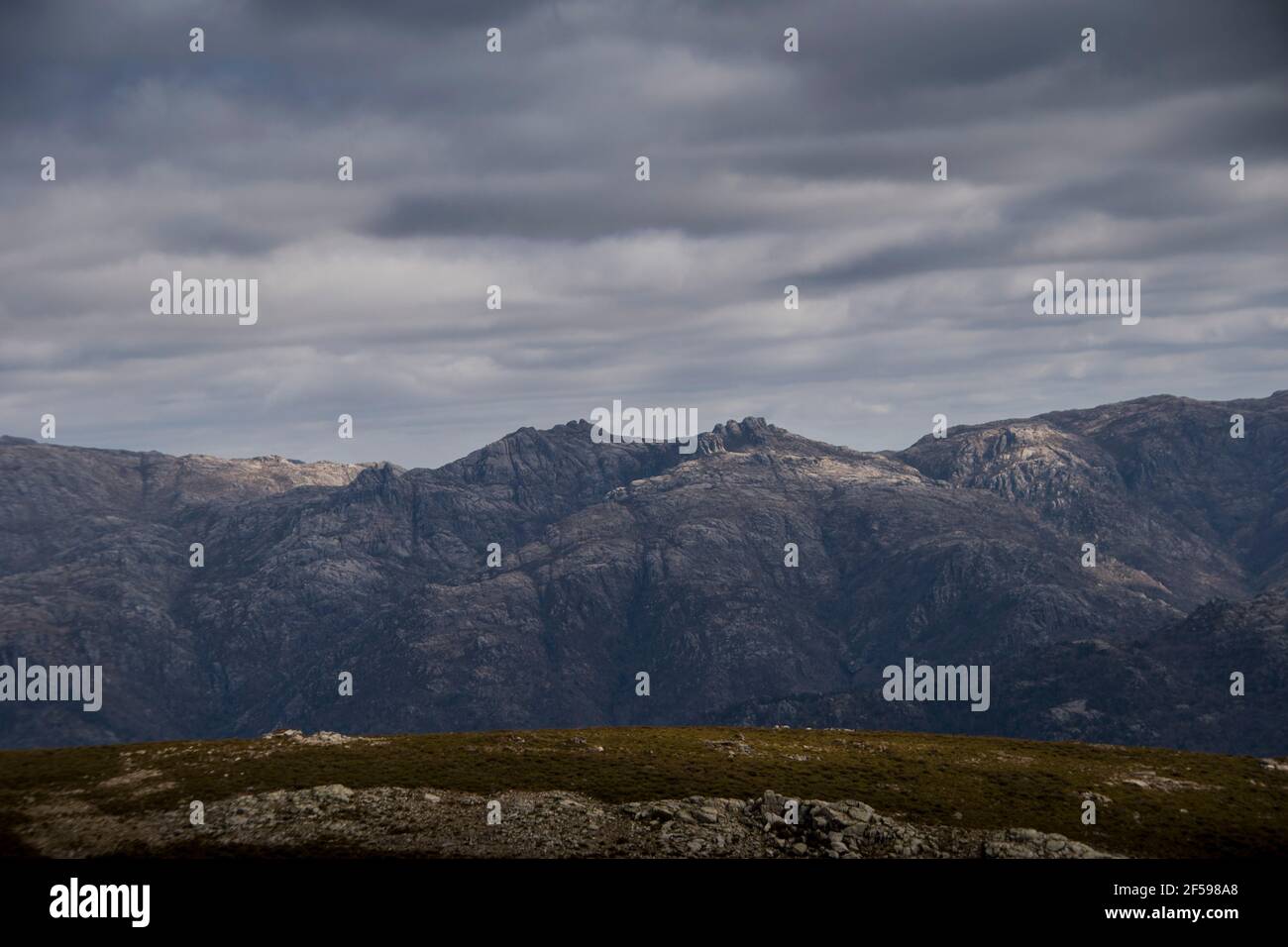 Paesaggio roccioso di montagna in una nuvolosa giornata di primavera, come l'ombra dalle nuvole coprono le vette rocciose del paesaggio Foto Stock