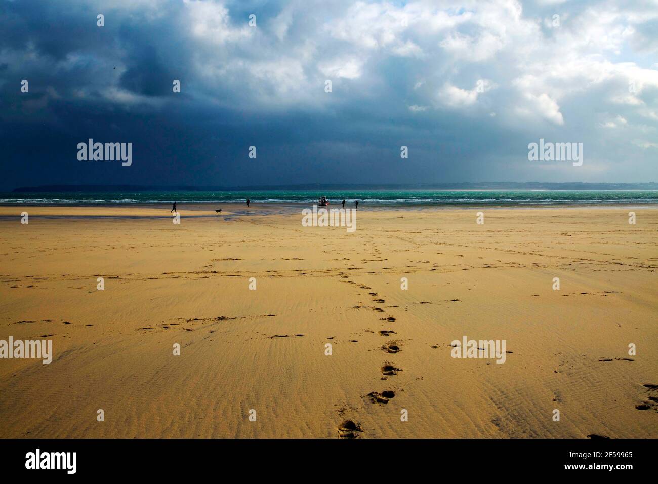 Spiaggia di St Ives a bassa marea con le impronte della sabbia, Cornovaglia, Inghilterra, Regno Unito con le nuvole drammatiche Foto Stock