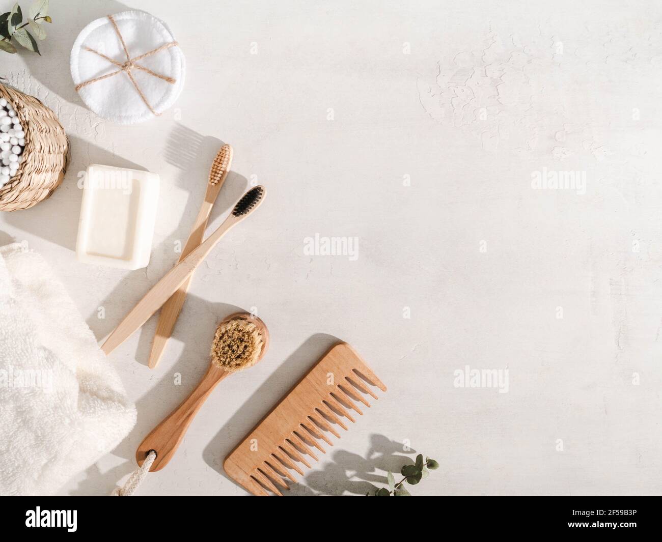 Vari articoli eco-compatibili: Spazzolini da denti, spazzola per capelli, salviette di cotone riutilizzabili, salvietta bianca e spazzola per il viso su sfondo bianco. Vista dall'alto. Spazio di copia Foto Stock