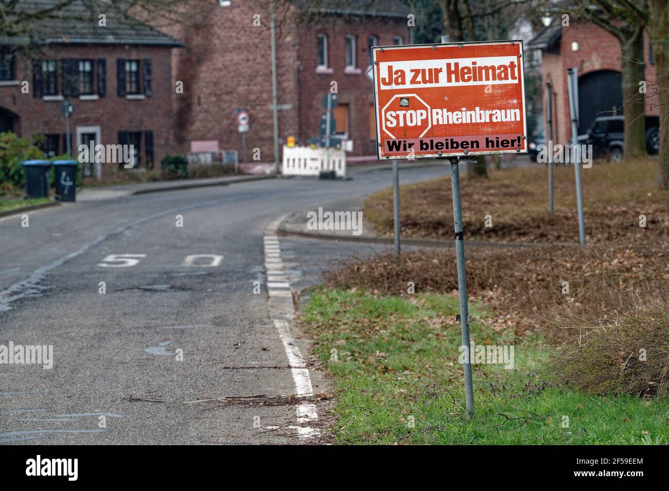 25 marzo 2021, Renania Settentrionale-Vestfalia, Berverath: Su una strada c'è un cartello con lo slogan 'Sì alla patria - Stop Rhine Brown - We stay here'. Il villaggio è quello di far posto alla miniera di lignite a cielo aperto di Garzweiler. La miniera di Garzweiler è stata un campo di battaglia politico in NRW per decenni. Una nuova decisione di spicco dà luogo ad un altro controverso dibattito in seno al parlamento statale sulle delocalizzazioni forzate degli abitanti dei villaggi e sui posti di lavoro che andranno persi. (A dpa 'decisione di Lignite: Il governo vuole nuovi posti di lavoro') Foto: Henning Kaiser/dpa Foto Stock