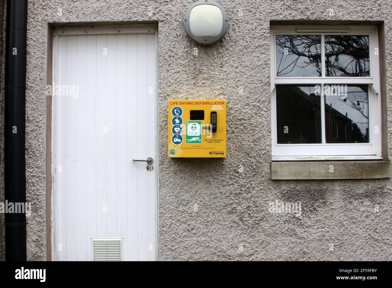 Sanquhar, Dumfries & Galloway, Scozia, Regno Unito. 22 Mar 2021. Defibrillatore salvavita per uso pubblico sulle pareti dell'edificio Foto Stock