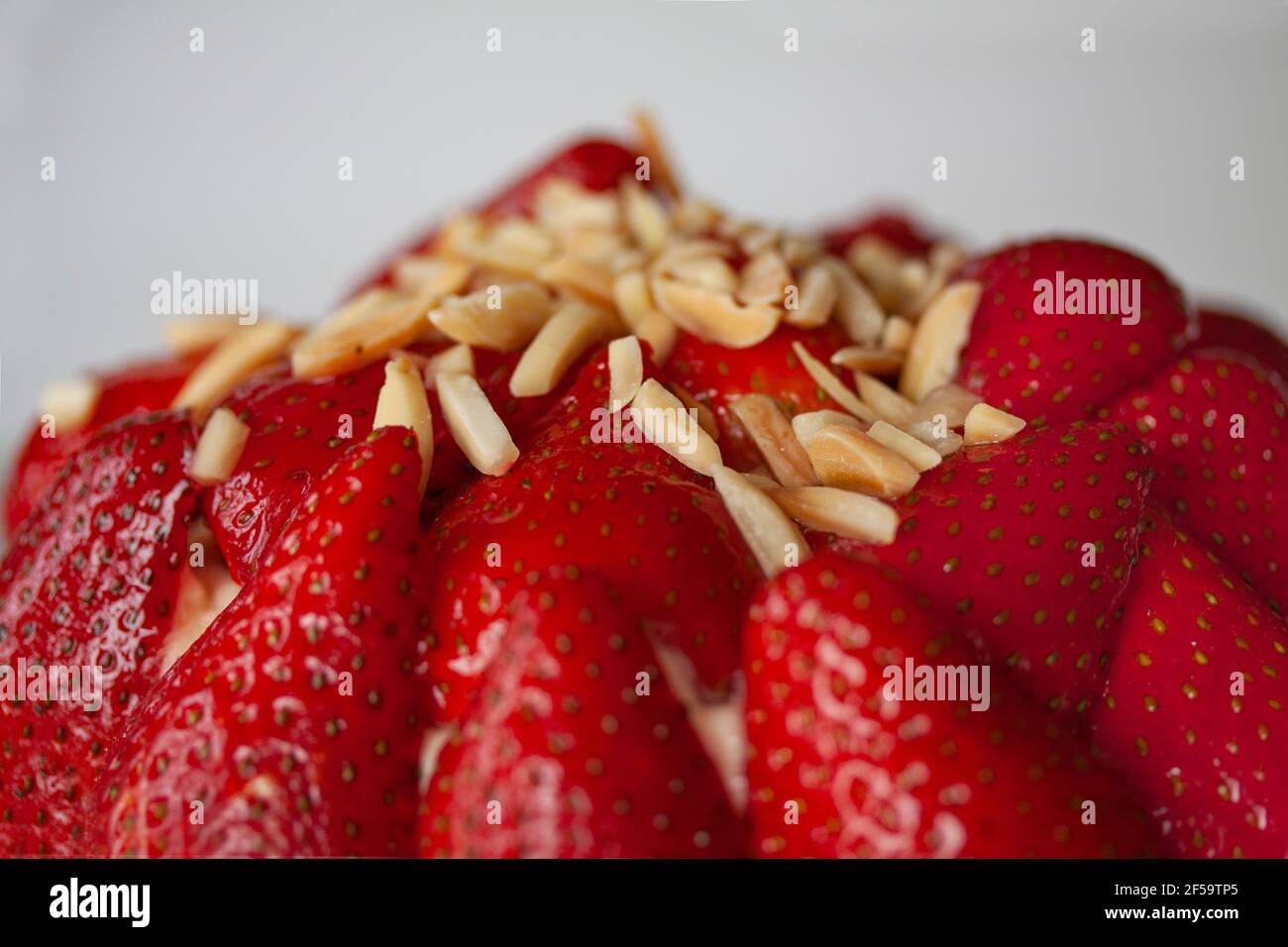 Torta di fragole con mandorle, cioccolato fondente e panna montata alla vaniglia. Primo piano dell'immagine. Foto Stock
