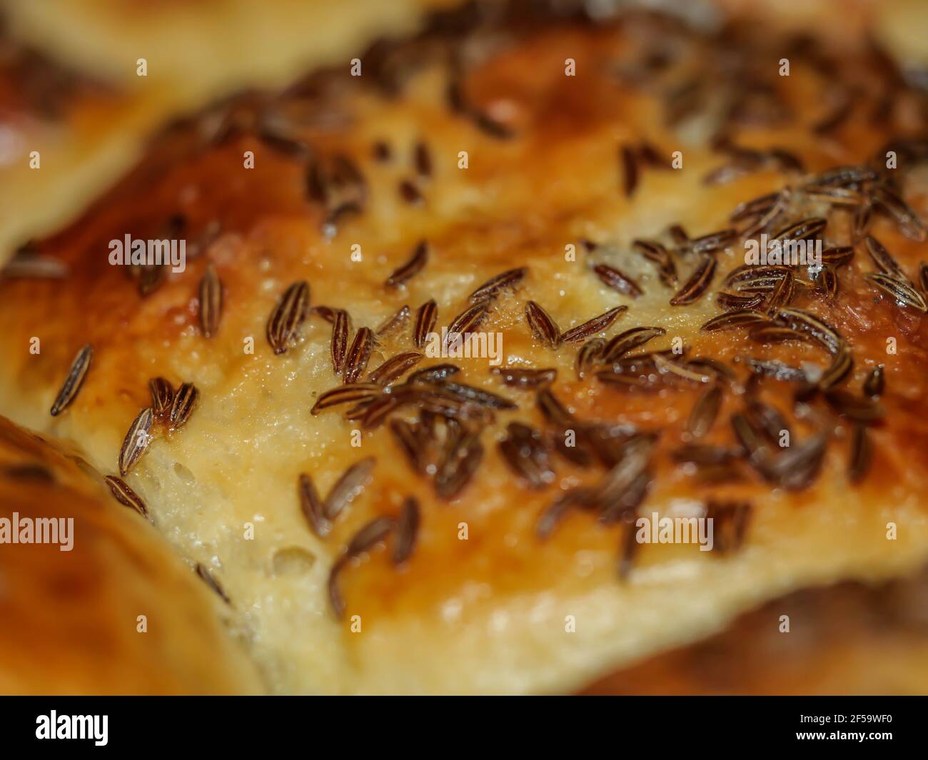 Ciambelle al forno smaltate all'uovo di cumino in una casseruola nera fresca Foto Stock