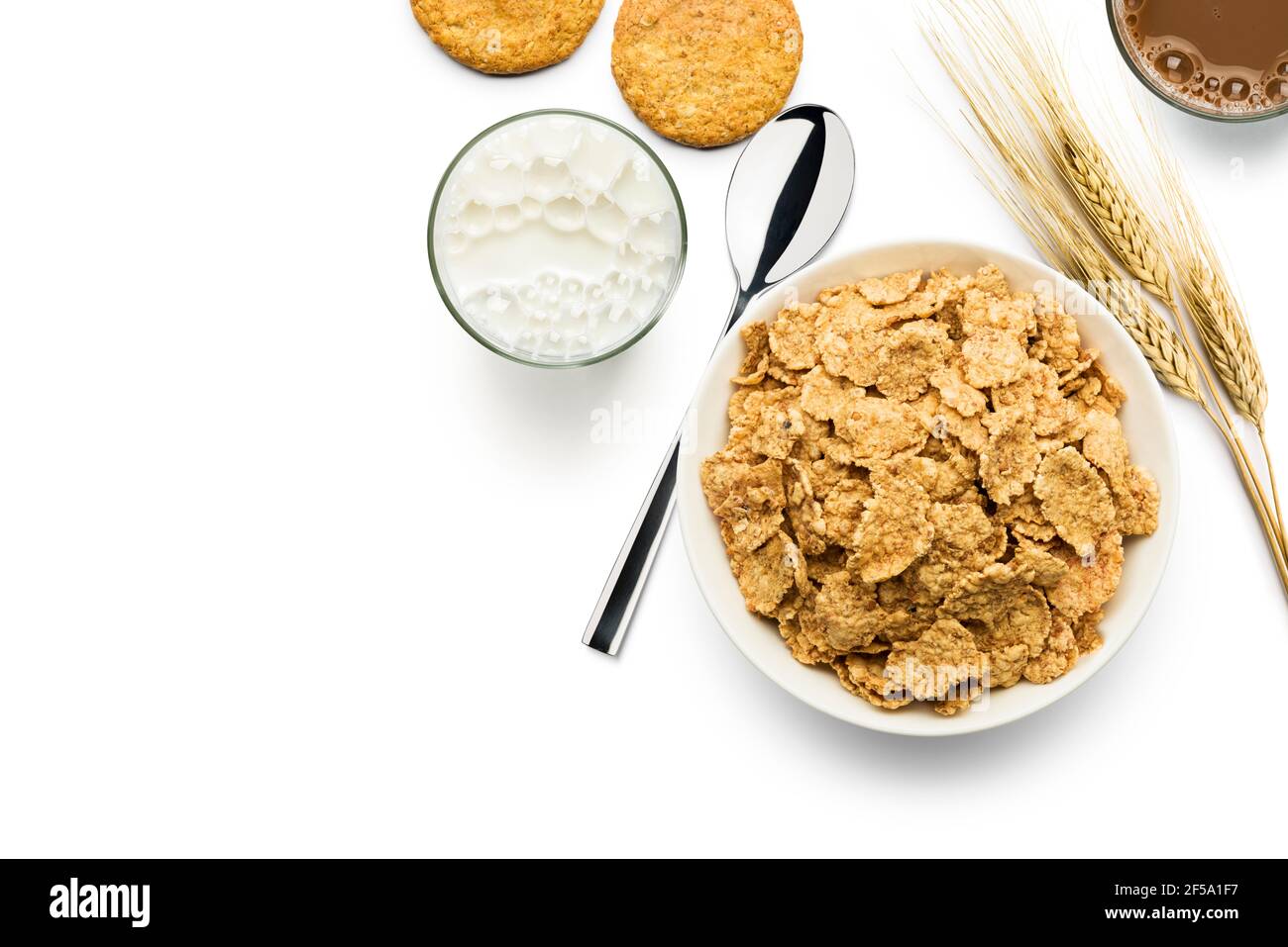 Vista dall'alto ciotola con fiocchi di mais integrali con latte su sfondo bianco Foto Stock