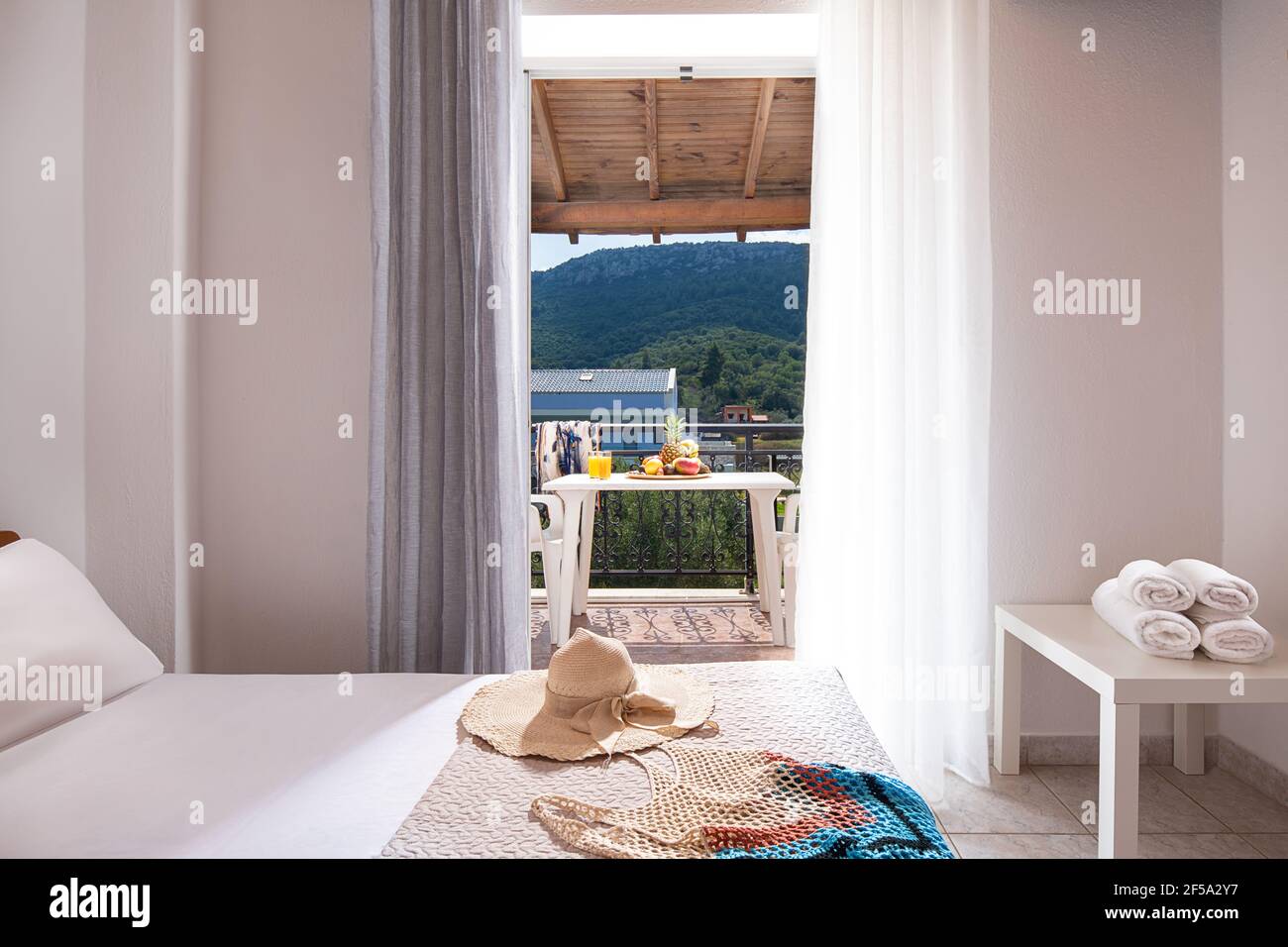 Closeup di porta aperta al balcone vista estate con mobili da terrazza, soffitto in legno, interno bianco della camera da letto vuota, in Europa apa lato campagna Foto Stock