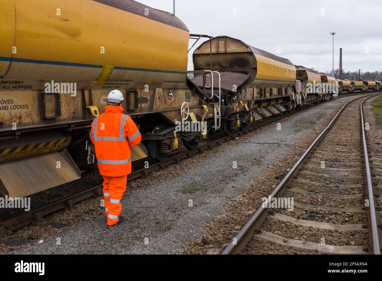 Un operaio ferroviario che ispeziona un treno di infrastrutture ferroviarie prima della partenza per costruire HS2 nel nord dell'Inghilterra. Foto Stock