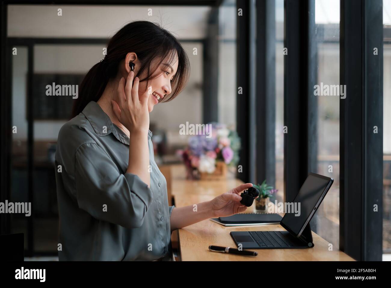 Giovane donna d'affari Pretty sorridente e seduto in ufficio domestico. Lavoro da casa concetto. Foto Stock