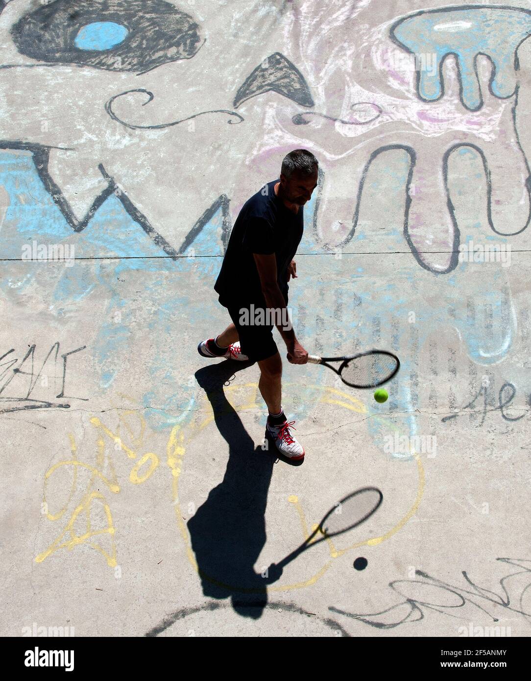 Roma, Italia. 25 Marzo 2021. 25 marzo 2021 : un uomo gioca a tennis durante il tempo libero sotto uno dei ponti lungo il Tevere a Roma Credit: Independent Photo Agency/Alamy Live News Foto Stock