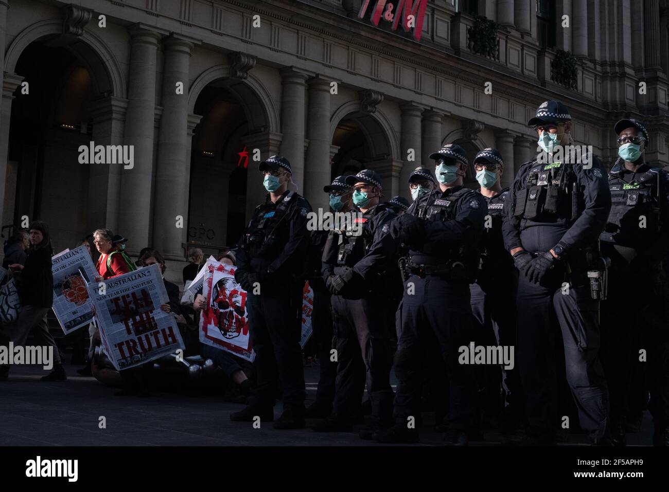 Melbourne, Australia. 25 marzo 2021. I team di risposta all’ordine pubblico si riuniscono in gran numero per arrestare i membri del gruppo di attivisti sul clima Extinction Rebellion per aver bloccato un incrocio nel CBD di Melbourne per protestare contro la repressione da parte di Rupert Murdoch della questione del cambiamento climatico nelle notizie australiane. Ciò segue una settimana di azioni dirompenti da parte del gruppo al fine di sensibilizzare l'opinione pubblica e la Confederazione sui cambiamenti climatici. Credit: Jay Kogler/Alamy Live News Foto Stock