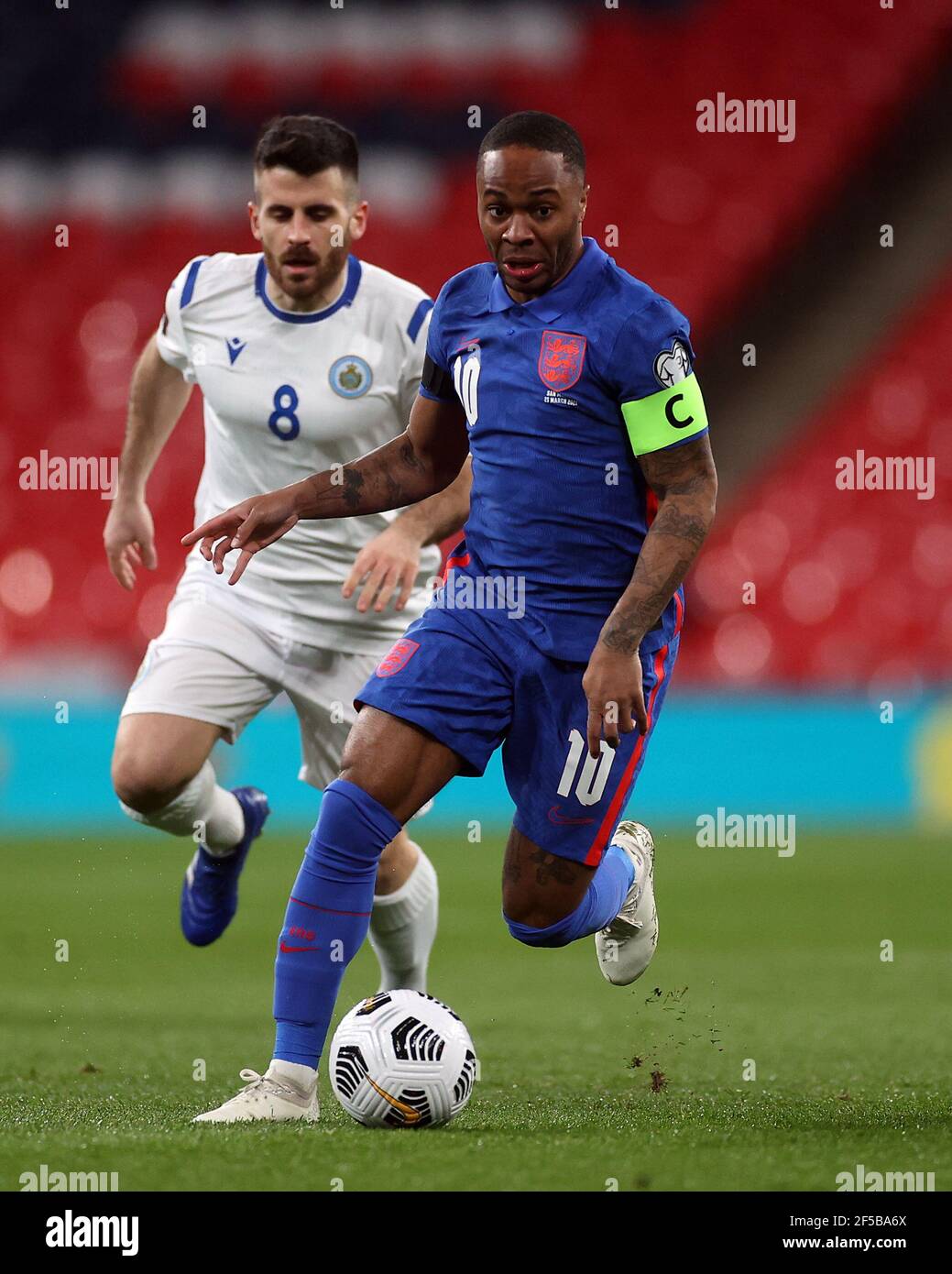 L'inglese Raheem Sterling e Enrico Golinucci di San Marino (a sinistra) combattono per la palla durante la partita di qualificazione della Coppa del mondo FIFA 2022 allo stadio Wembley di Londra. Data immagine: Giovedì 25 marzo 2021. Foto Stock