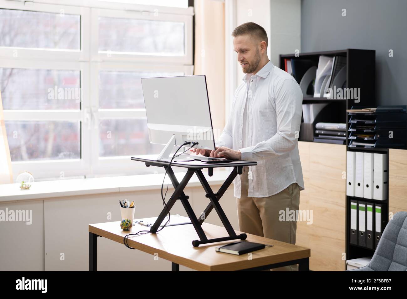 Supporto da scrivania ad altezza regolabile per computer da ufficio Foto Stock