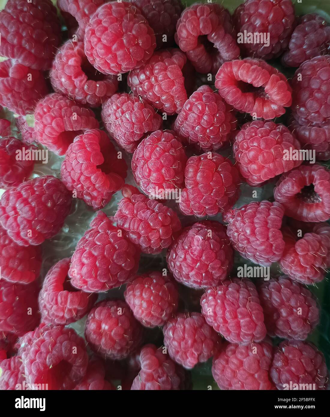 Mucchio di frutti di raspberry maturi orizzontale primo piano sfondo. Macro shot di mazzo di frutti di raspberry freschi Foto Stock
