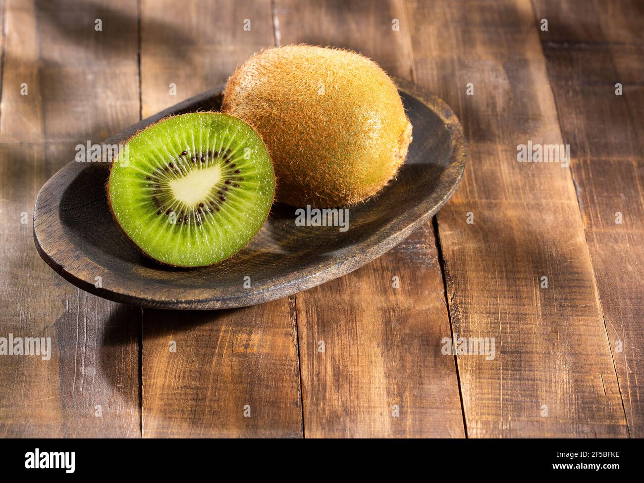 Bacche di kiwi fresche - Actinidia deliziosa. Legno di fondo Foto Stock