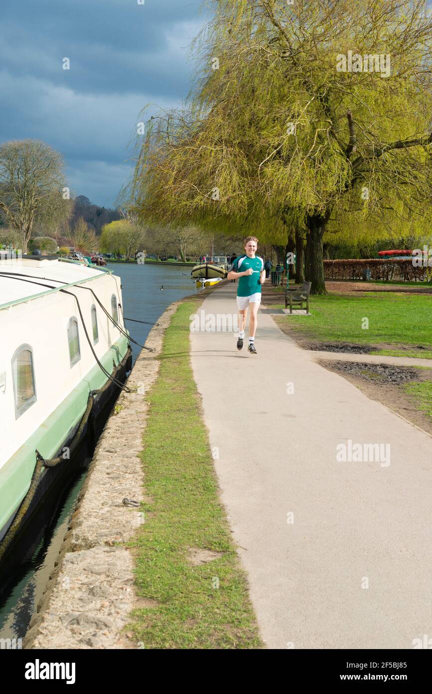 Boy Running per allenarsi lungo il Tamigi Path a Henley-on-Thames, Oxfordshire, Inghilterra, Regno Unito Foto Stock