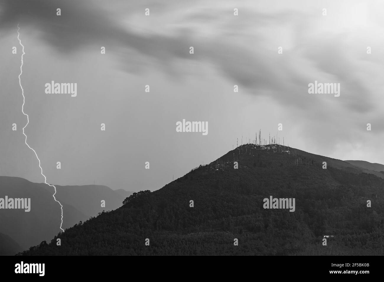 Fotografia in bianco e nero del picco del vulcano Pichincha con un fulmine temporale, Quito, Ecuador. Focus sulla vetta della montagna. Foto Stock
