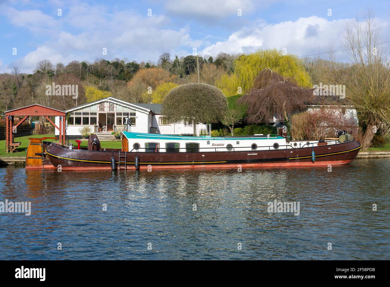 Dutch Torque ormeggiato fuori da una casa sul fiume Rod Eyot Island vicino a Henley-on-Thames, Oxfordshire, Inghilterra, Regno Unito Foto Stock