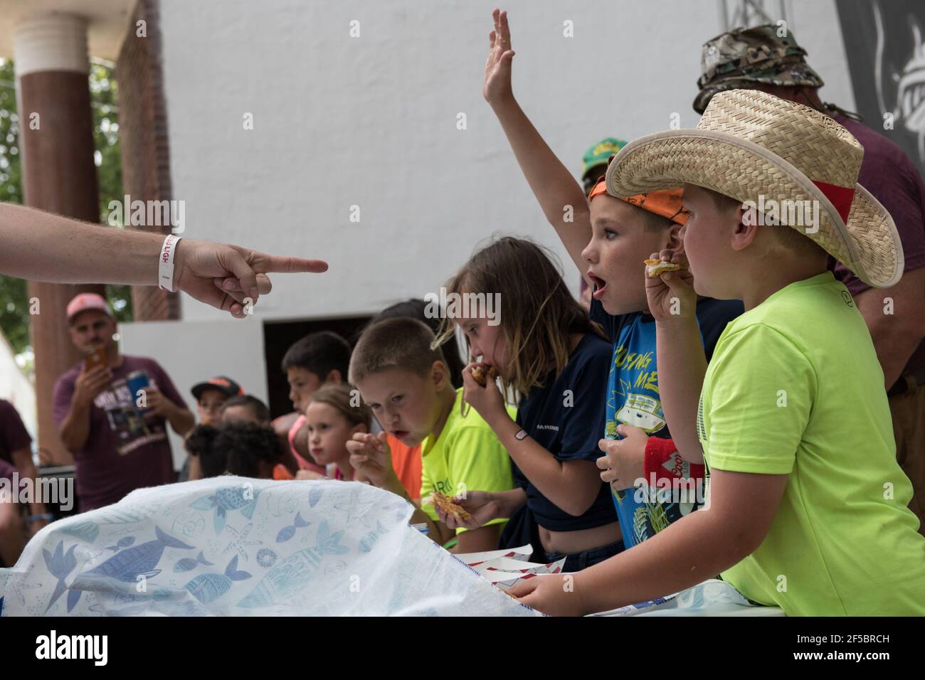 I giovani concorrenti divorano con impazienza il pesce gatto all'annuale gara di noodling per bambini dell'Okie Noodling Tournament's Children's Eating a Paul's Valley, Oklahoma. Foto Stock