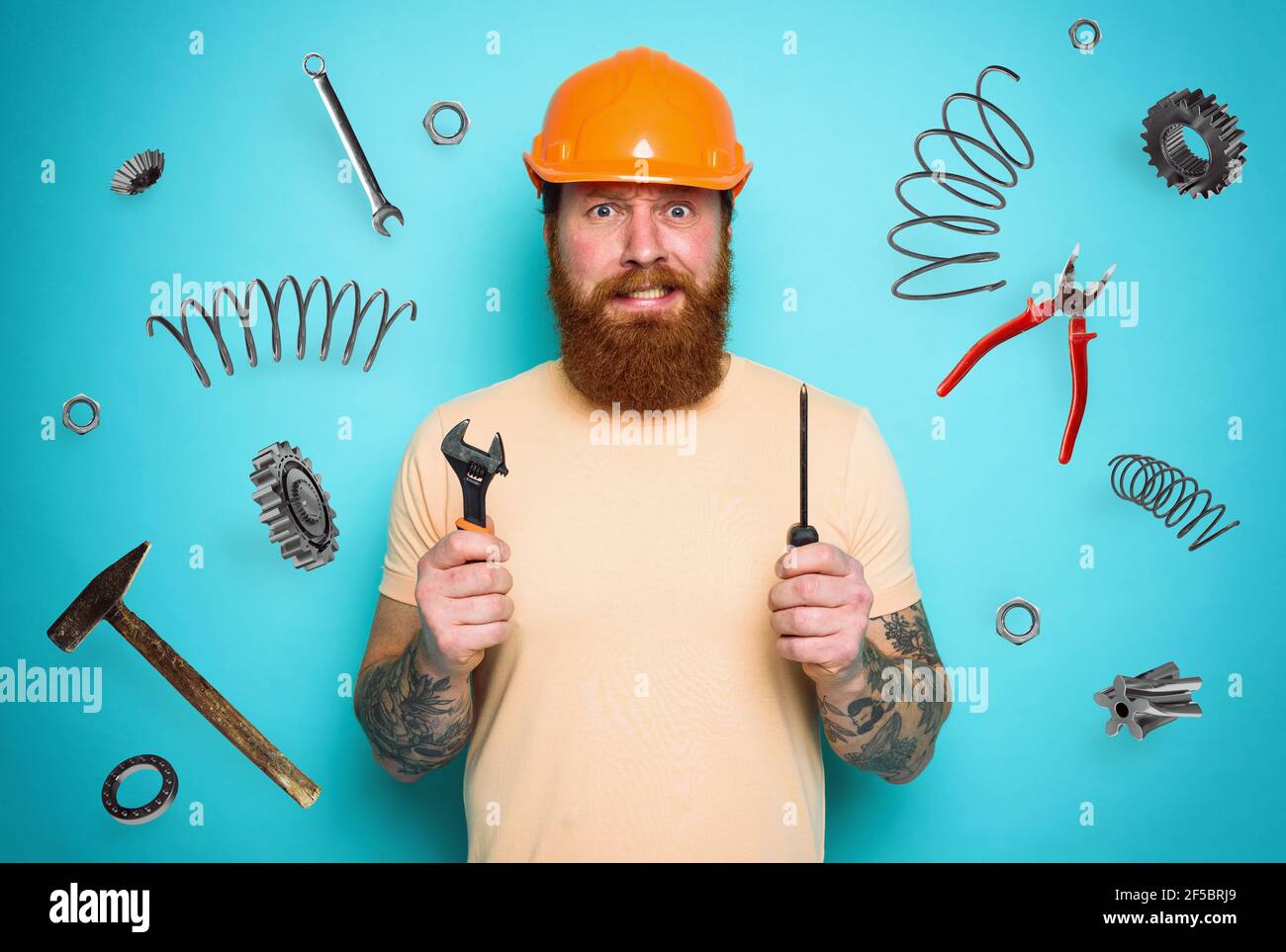 Uomo confuso con cacciavite e chiavi. Espressione preoccupata e incerta. Sfondo ciano Foto Stock