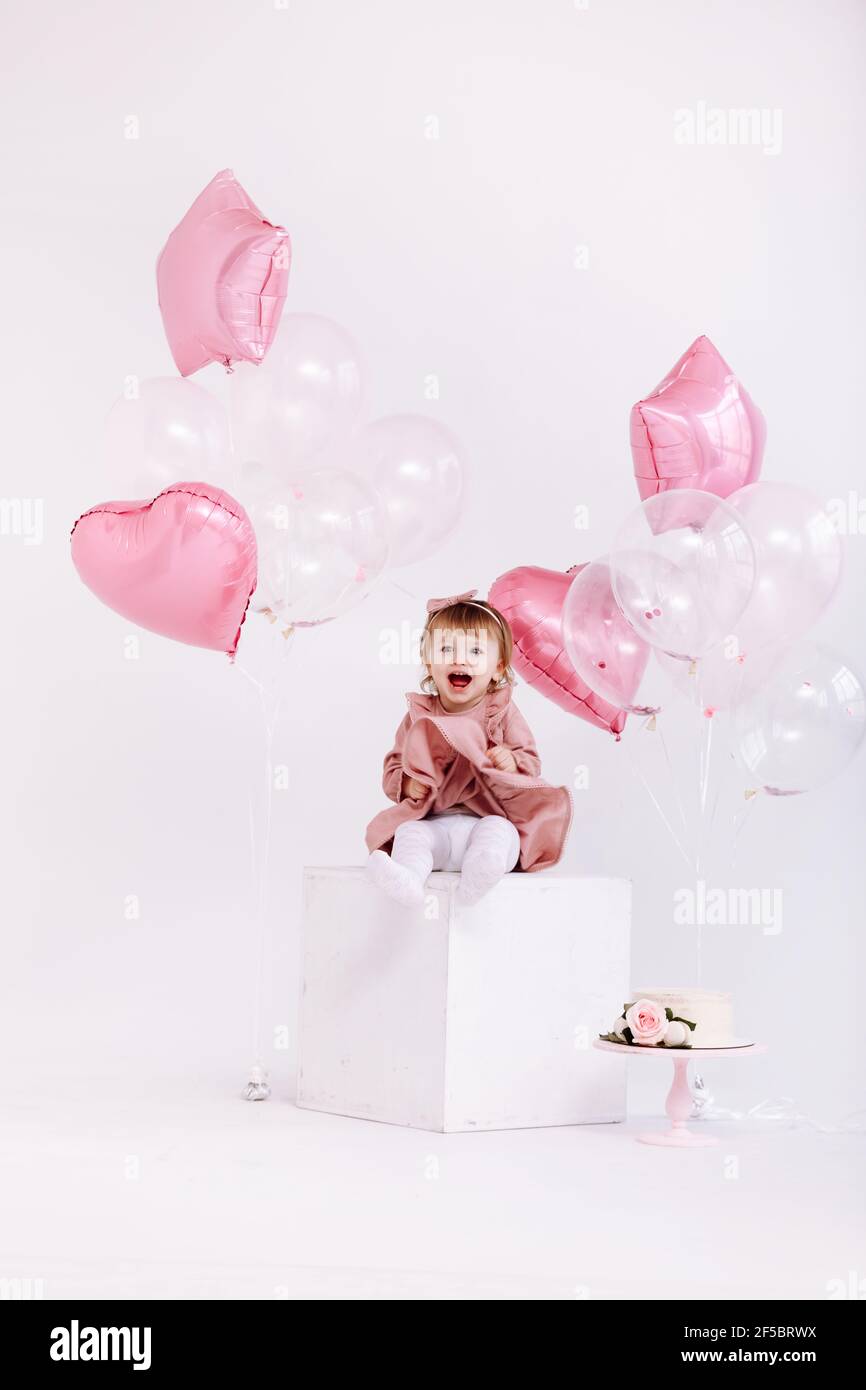 buon compleanno bambina di 2 anni in abito rosa. torta bianca con