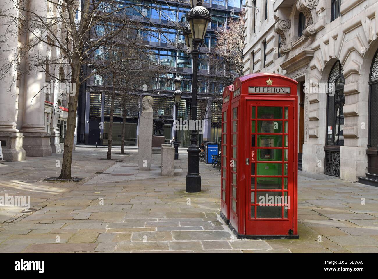 Tipiche cabine telefoniche londinesi circondate da una vecchia architettura londinese, Royal Exchange, Cornhill Foto Stock