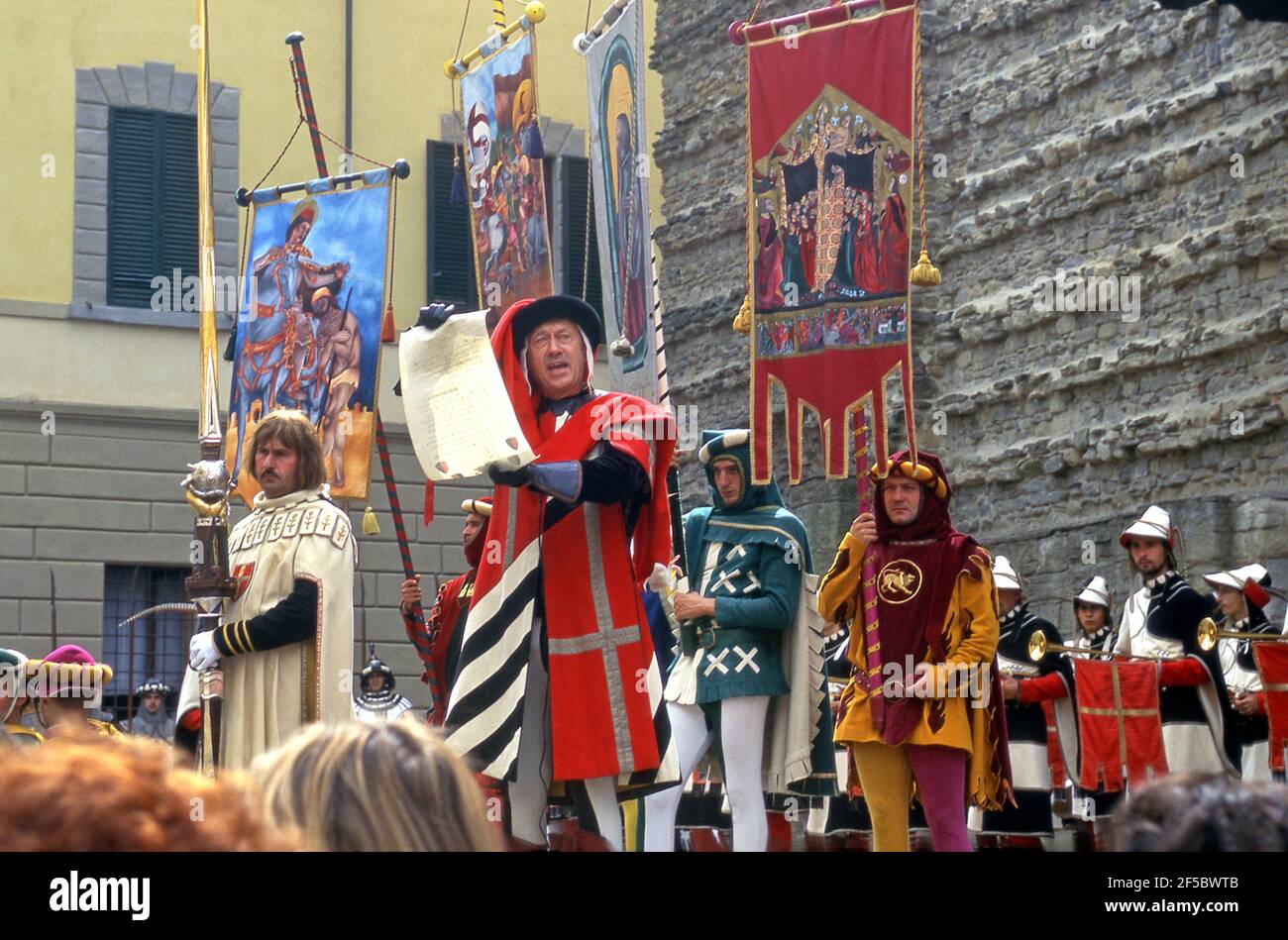 Un uomo vestito in costume d'epoca legge da un proclama in una festa medievale a Montevarchi, Italia Foto Stock