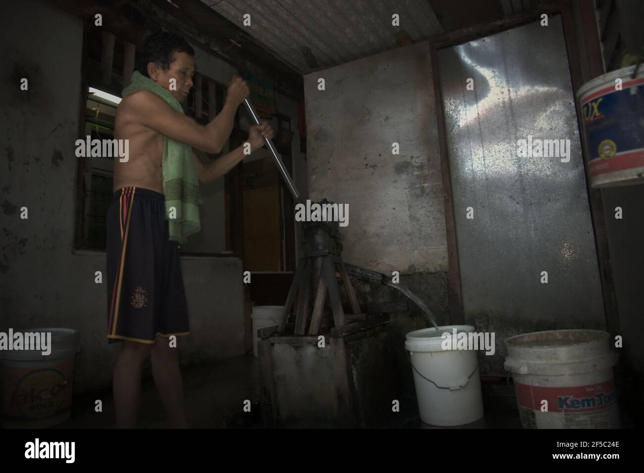 Un uomo che pompa acque sotterranee in un impianto idrico comunale in una densa area popolata a Giacarta, Indonesia. Dal 2015, l'efficienza del consumo di acqua è aumentata del 4% a livello globale, secondo quanto affermato dalle Nazioni Unite Water nel loro Summary Progress Update 2021, pubblicato il 1° marzo 2021 a Ginevra. "Con il ritiro del 17% delle risorse idriche disponibili, il mondo intero non viene considerato sottoposto a stress idrico", afferma la relazione. "Tuttavia, questo numero nasconde forti differenze regionali: In alcune regioni il livello di stress idrico è aumentato del 35% negli ultimi due decenni". Foto Stock