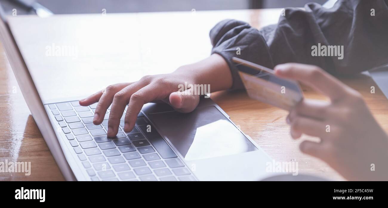 Shopping online. Donna asiatica che digita le informazioni della carta di credito con la tastiera del portatile per lo shopping online. Foto Stock